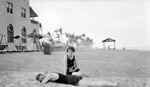 Unknown couple on beach, building, swinging chairs, and tent in background by Francis G. Wagner and Nelson Poynter Memorial Library
